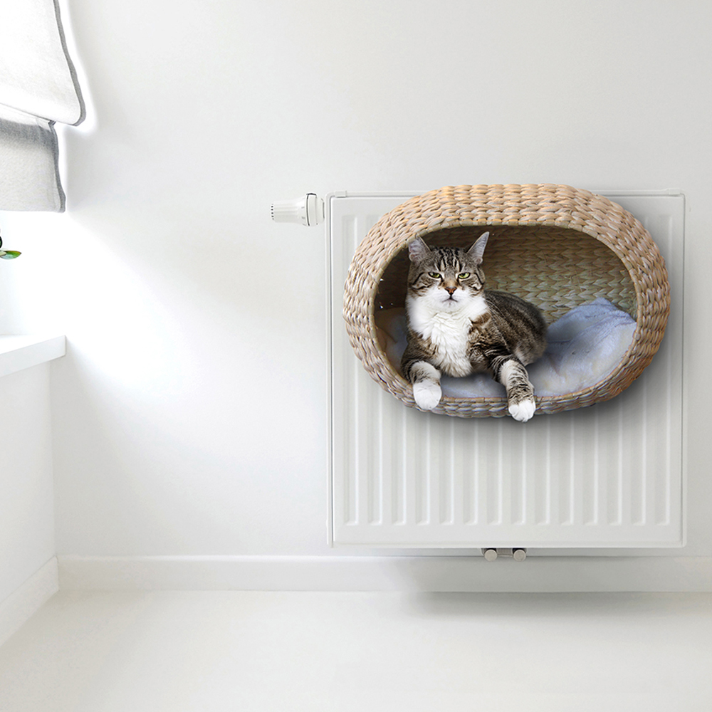 mand van waterhyacintbladeren aan radiator met kat erin