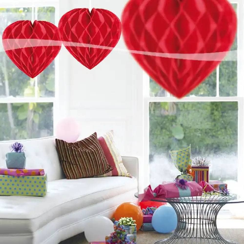 Drie hartvormige honeycombs in kamer met ballonnen en cadeaus