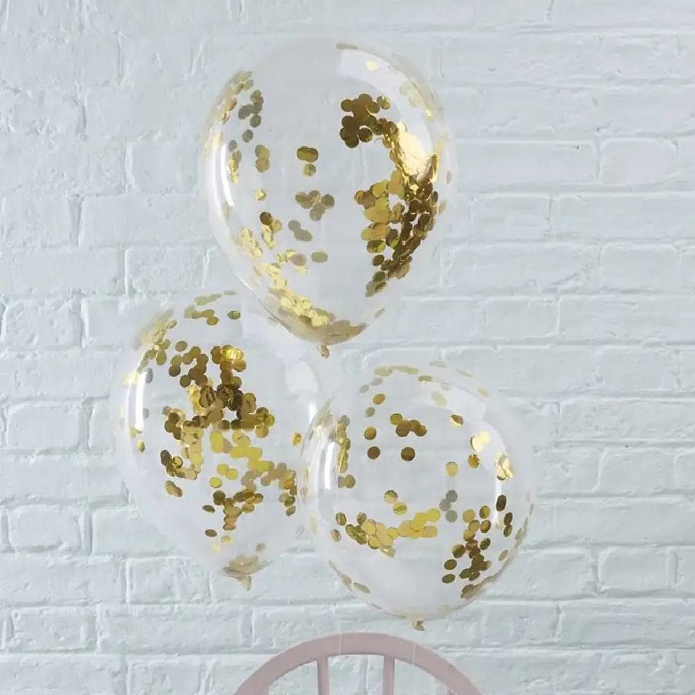 Drie transparante ballonnen met gouden confetti erin aan een stoel