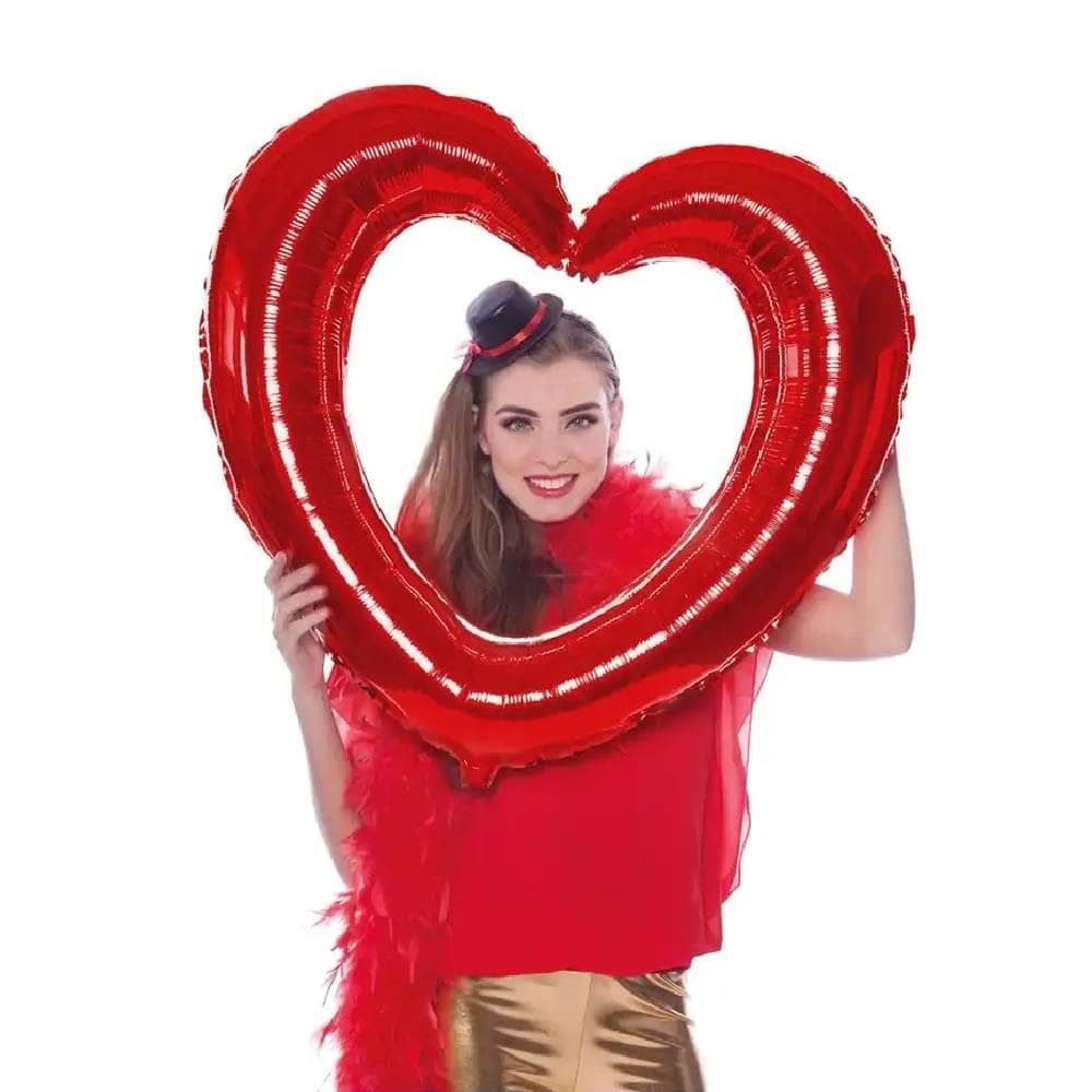Vrouw poseert met rood hartvormig folieballon frame