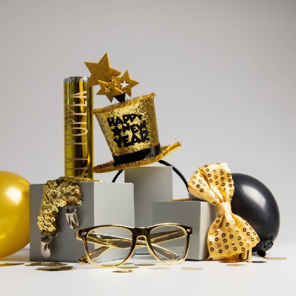 Gouden bril, ballon en strik met een zwarte ballon en een gouden party popper