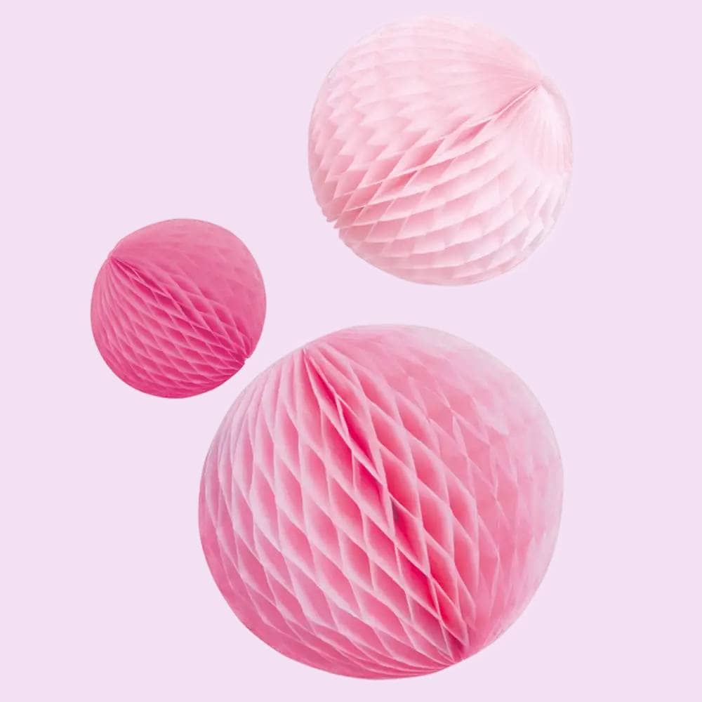 Drie honeycombs in roze tinten op lichtroze achtergrond