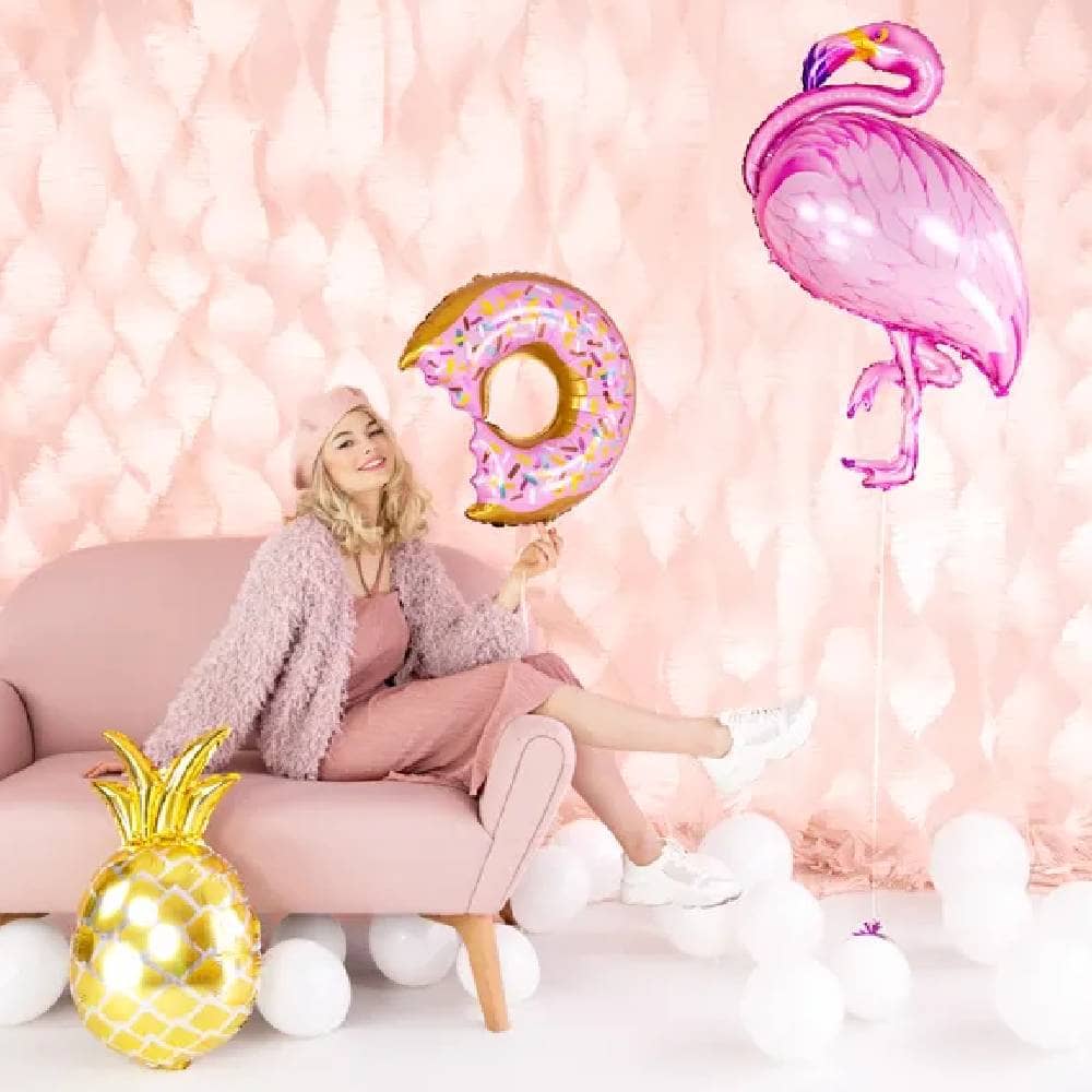 Vrouw op een bank met donut folieballon, flamingo folieballon en ananas folieballon