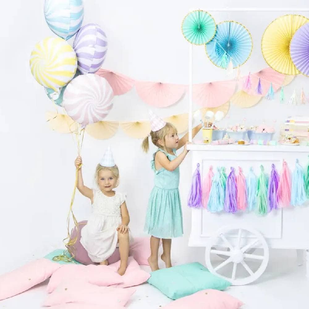 Twee meisjes in een kamer met snoepkar en pastelkleurige versiering
