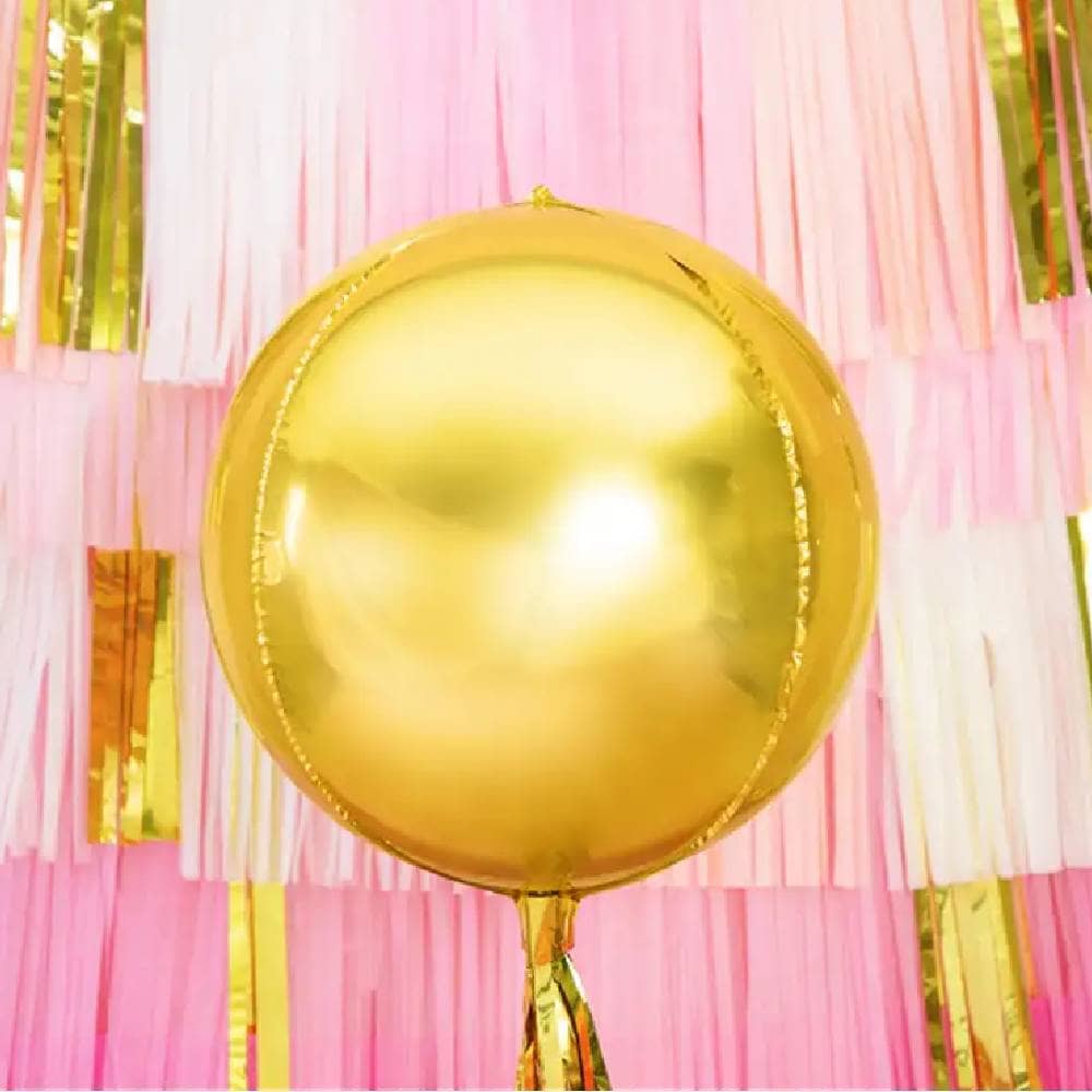 Grote gouden ballon met daarachter een roze achtergrond