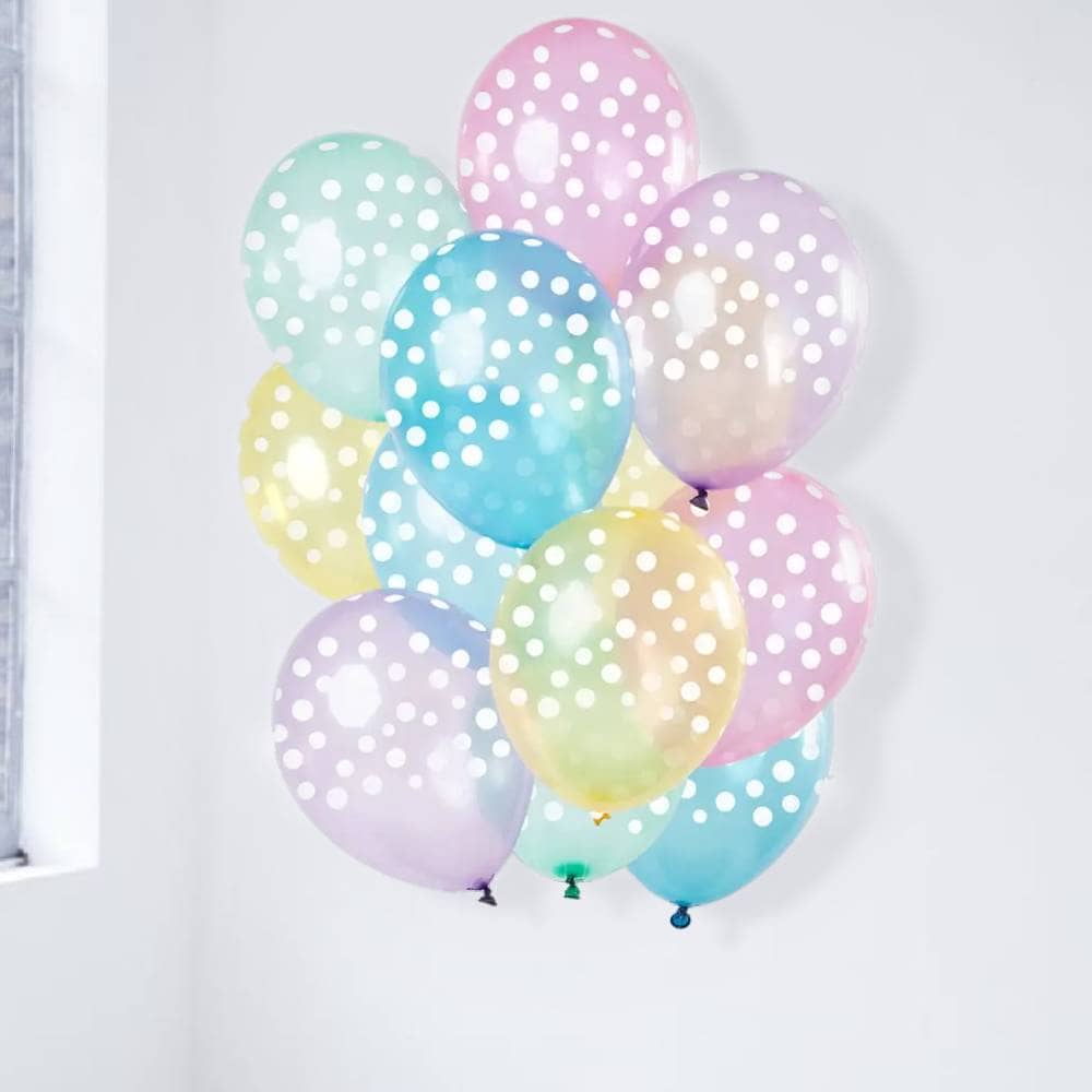 Set ballonnen naast een raam in verschillende pasteltinten met witte stippen