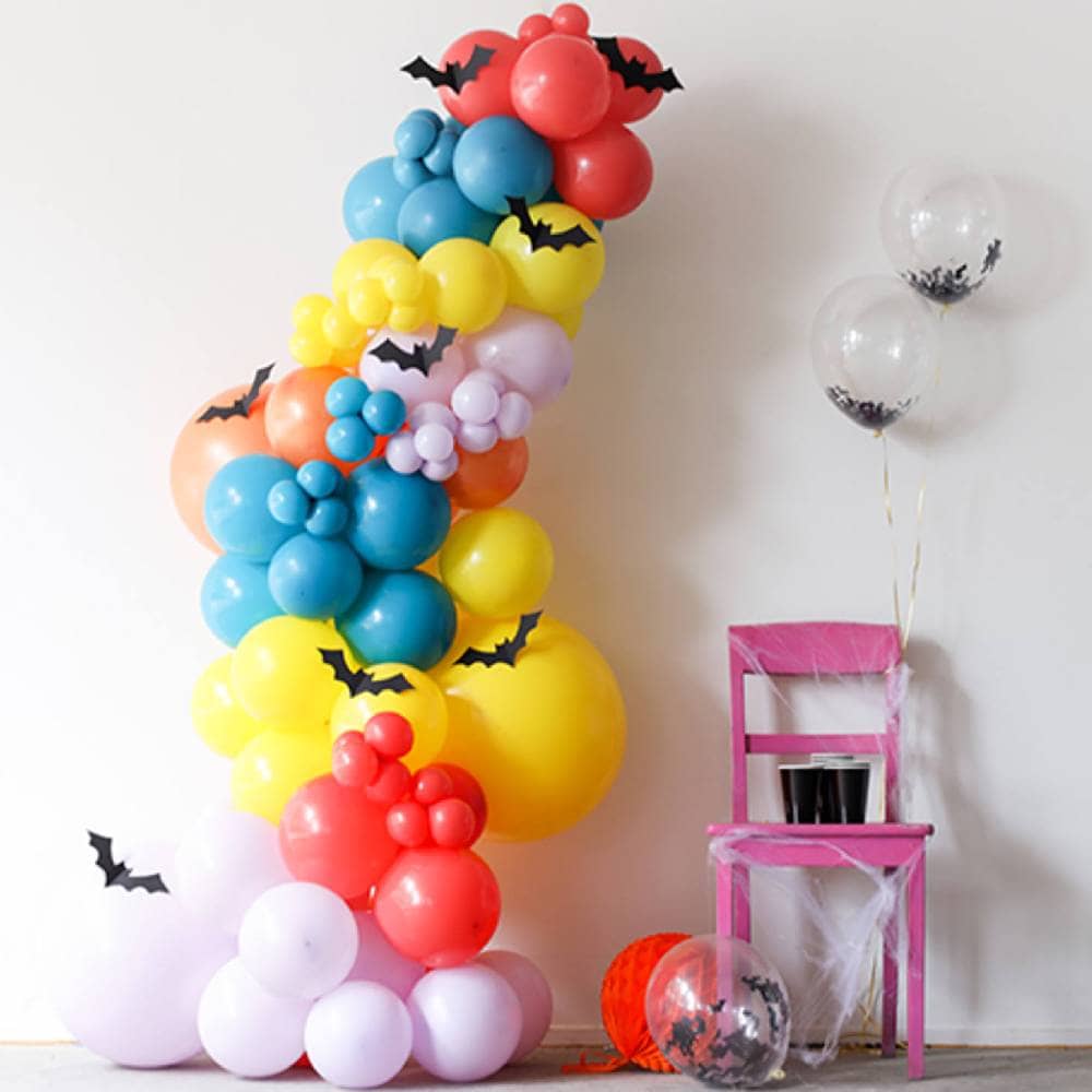 Multicolor ballonnenboog met daarop vleermuizen naast een stoel met vleermuisballonnen