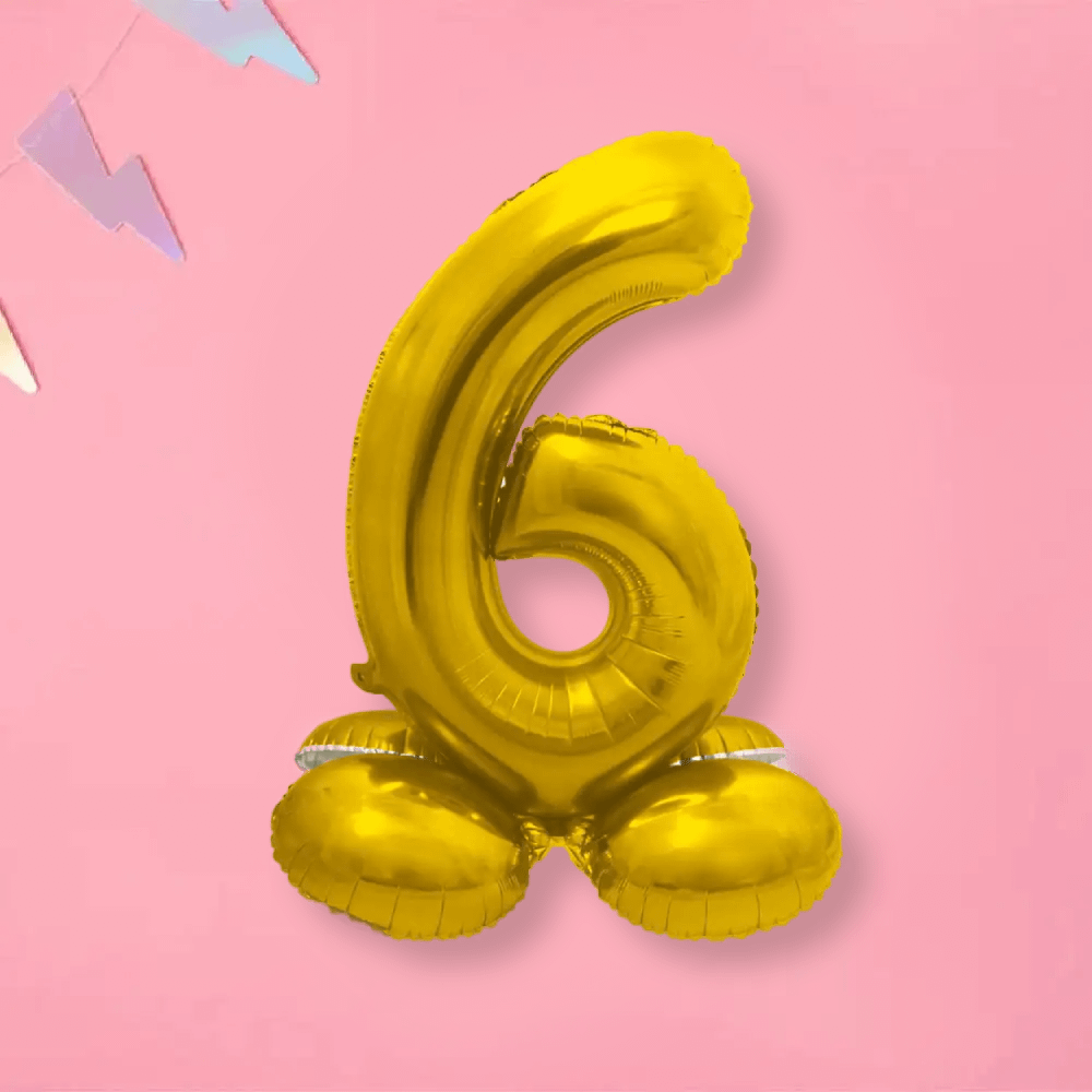 Folieballon cijfer 6 op standaard in het goud op een roze achtergrond met slinger in pasteltinten paars en blauw