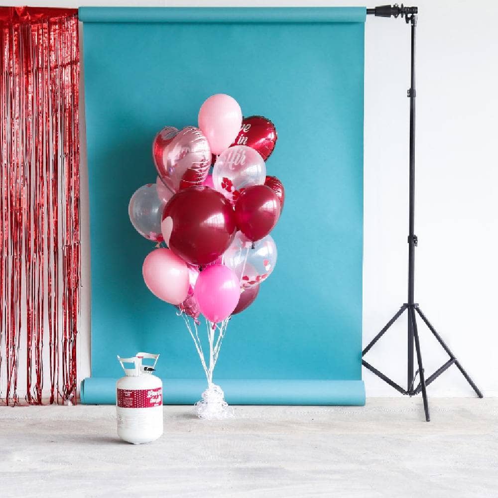 Heliumtank met rode, roze en transparante ballonnen met hartjes