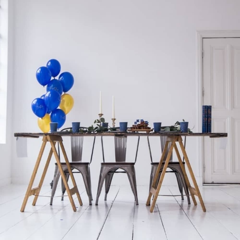 Gedekte tafel met donkerblauwe en gouden ballonnen