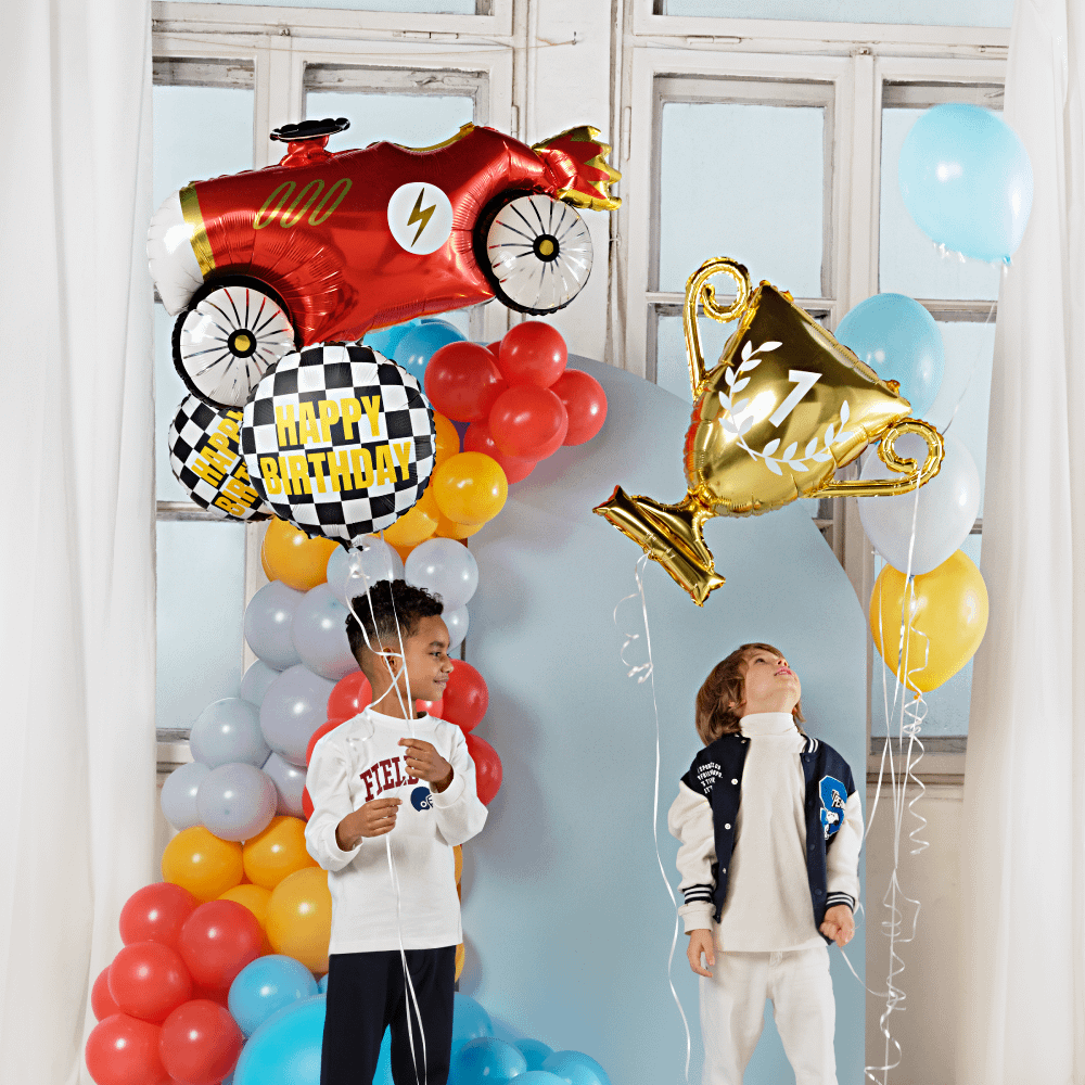 Twee jongen met auto en race folieballonnen