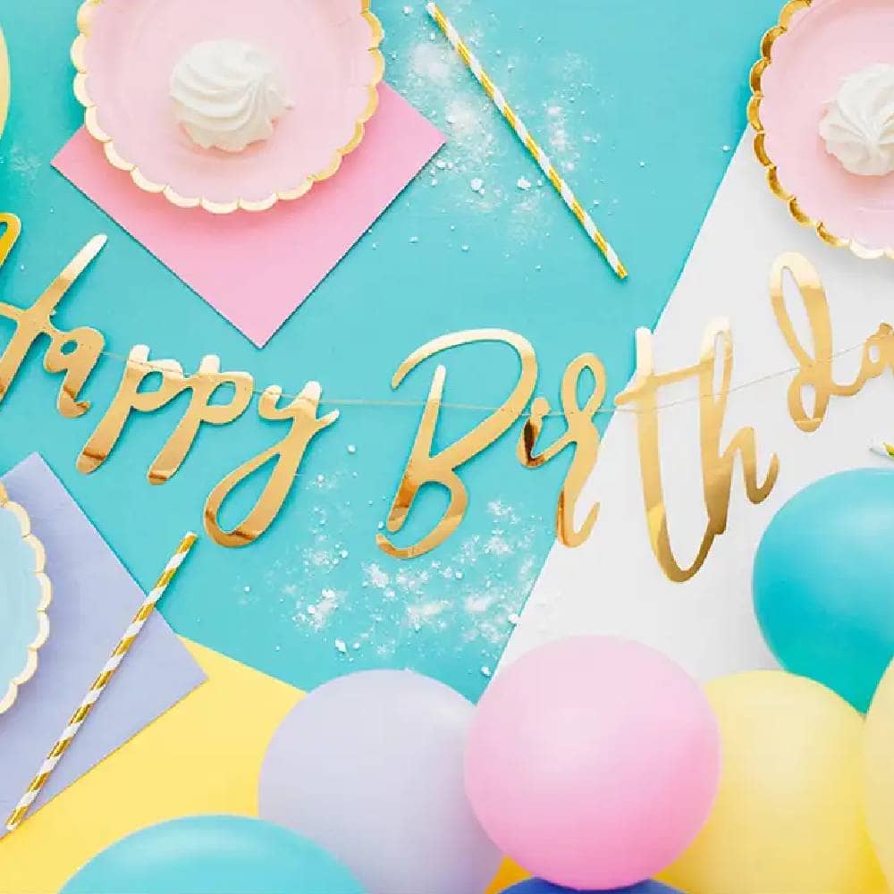 Tafel met ballonnen bordjes rietjes servetten en een happy birthday slinger
