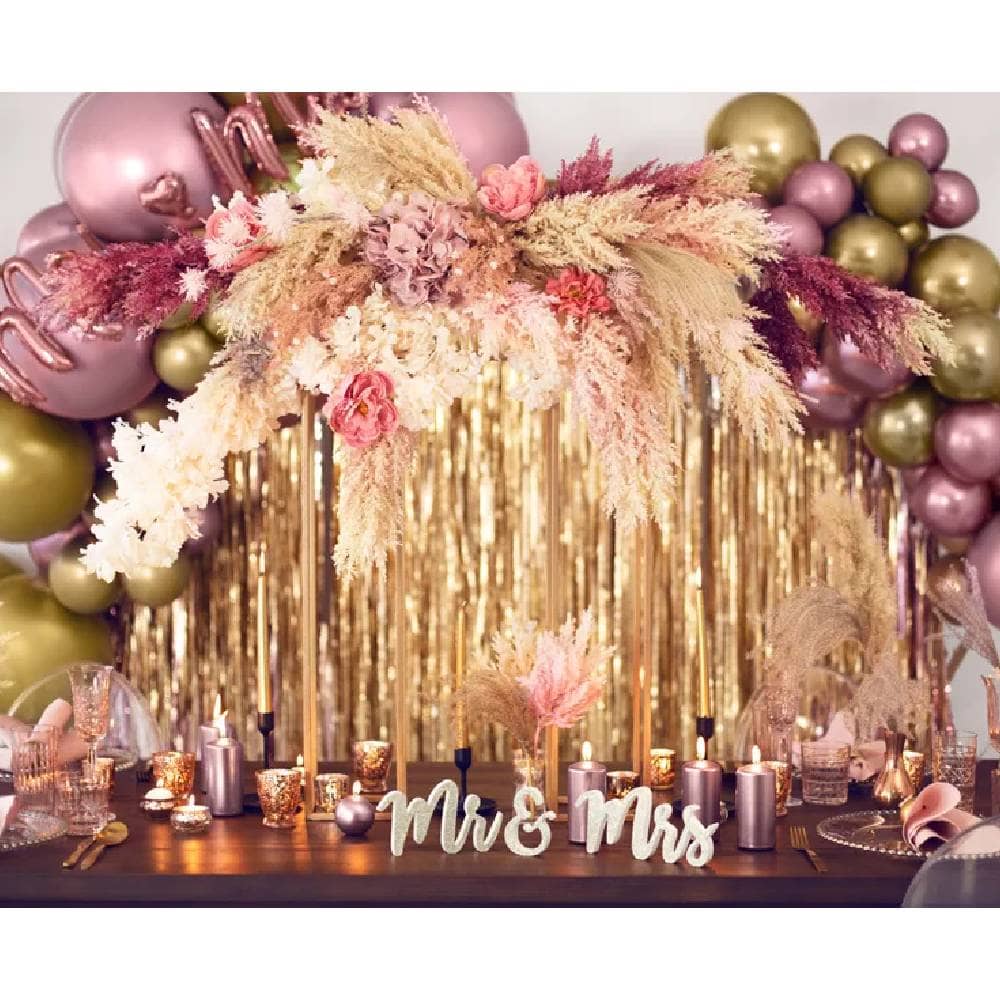 Versierde tafel met droogbloemen en roze en gouden ballonnen