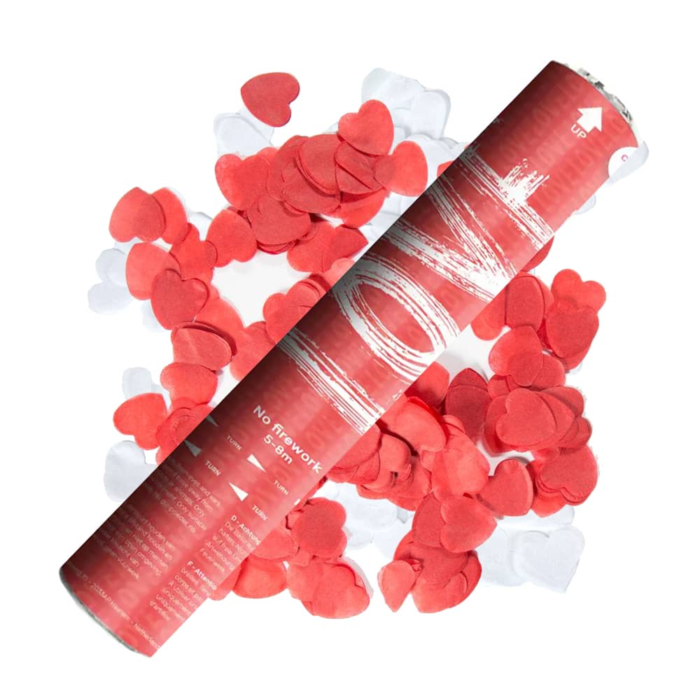 Rode party popper met wit en rode hartvormige confetti op de achtergrond