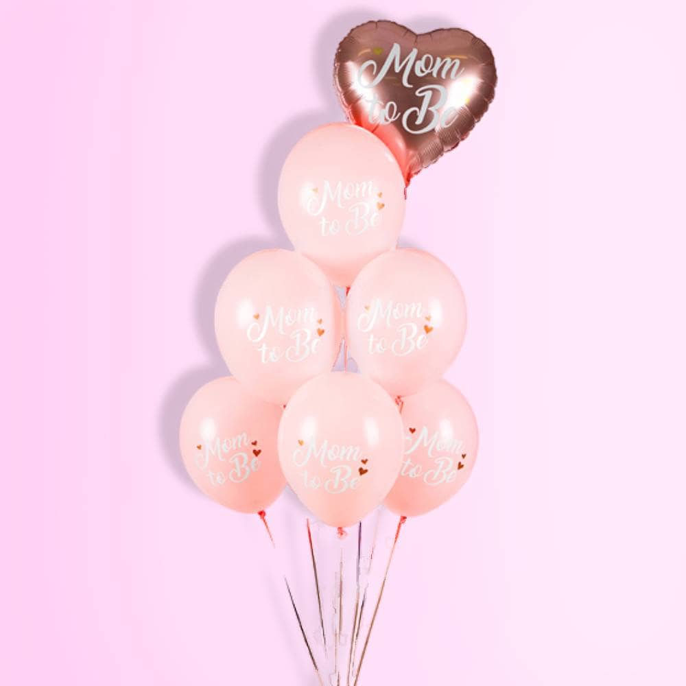 Roze ballonnen met de witte tekst 'mom to be' op een roze achtergrond
