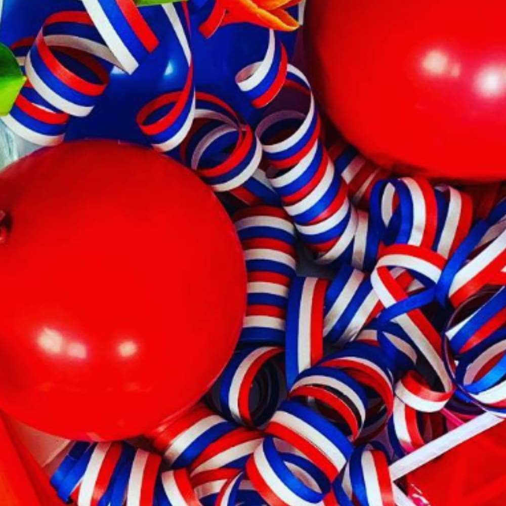 Serpentinerol in de kleuren rood, wit en blauw met rode ballonnen