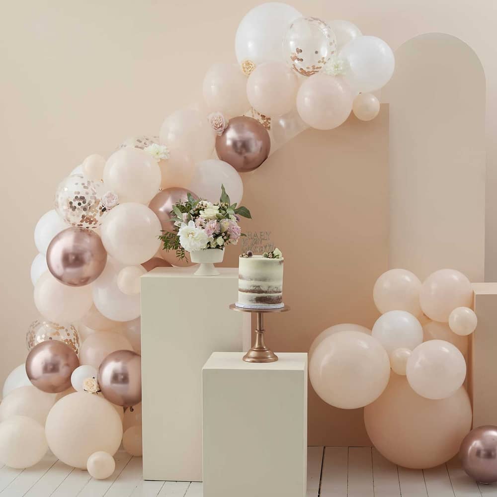 versierde ruimte met grote en kleine ballonnen in lichte roze kleuren en bloemen