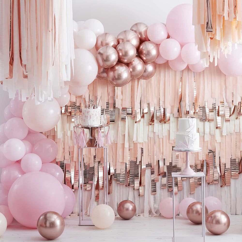 ruimte vol roze en rose gouden balonnen en streamers