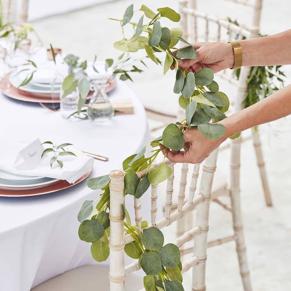 streng met kunst eucalyptus bladeren bij een gedekte tafel