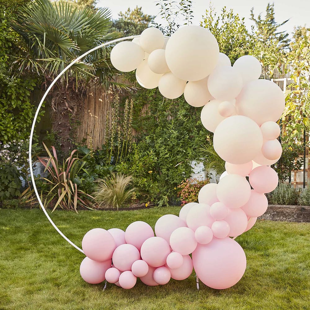 ronde witte boog met ivoorkleurige en roze ballonnetjes