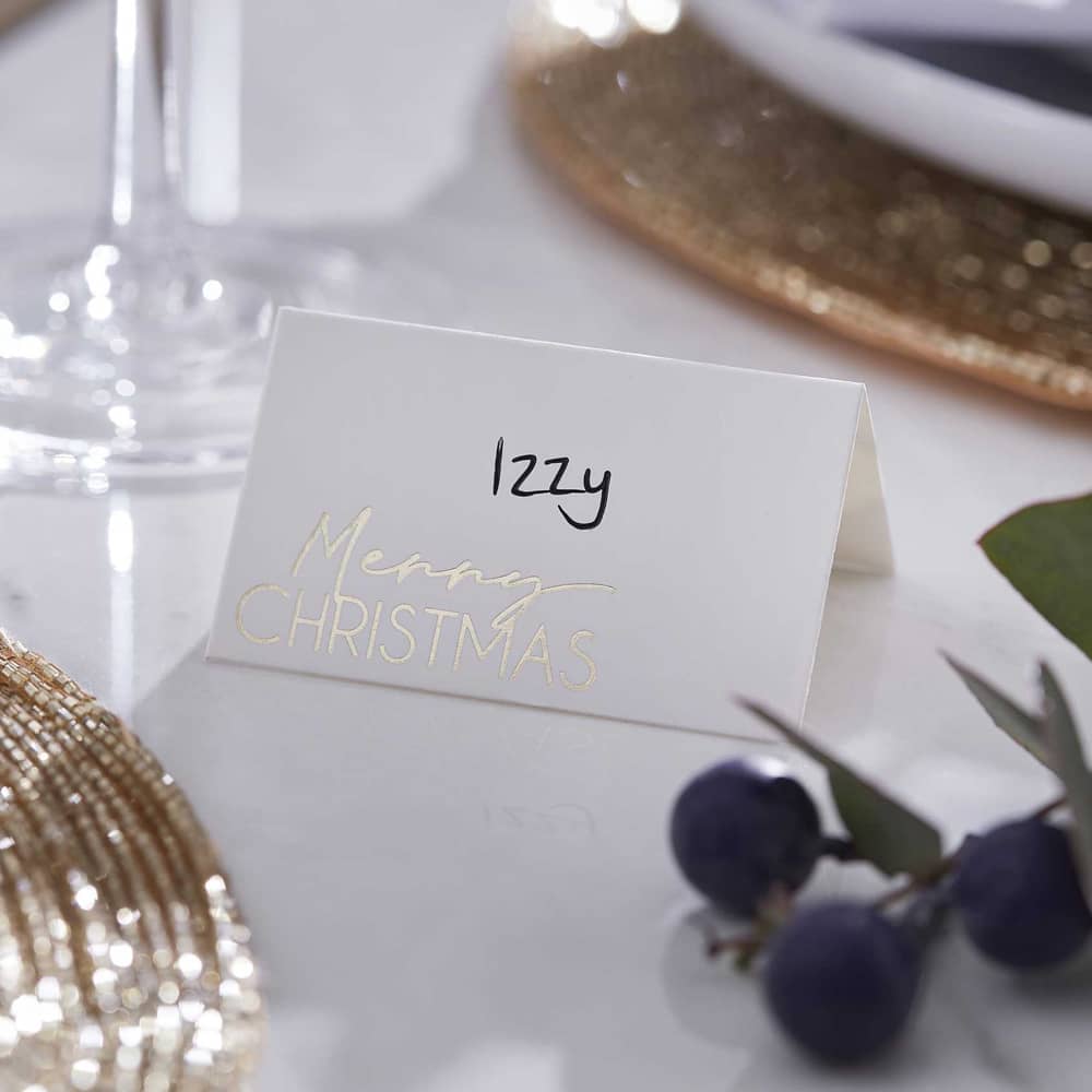 Wit tafelkaartje met merry christmas erop en de naam izzy