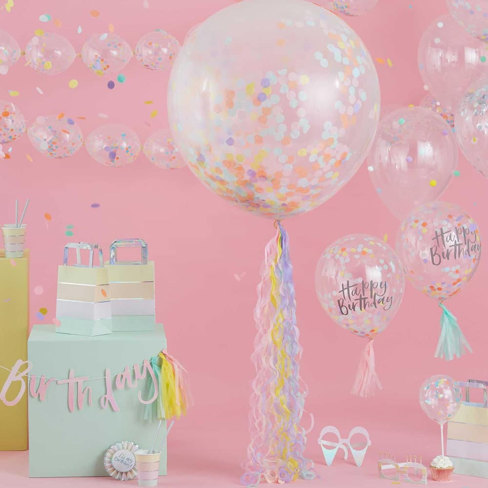 Kamer vol feestversiering zoals een grote ronde ballon met confetti erin