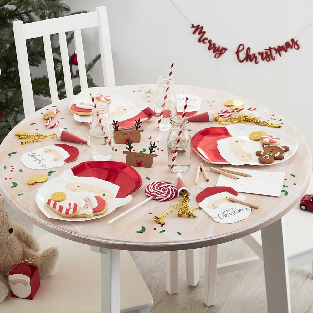 Kindertafel versierd voor kerst met kerstbordjes en snoep