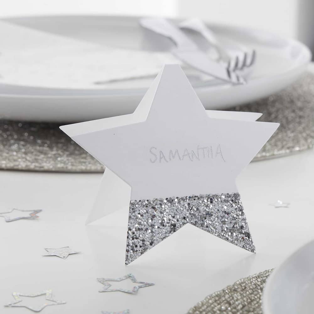 Tafelkaartje in de vorm van een sterretje met zilveren glitters op gedekte tafel