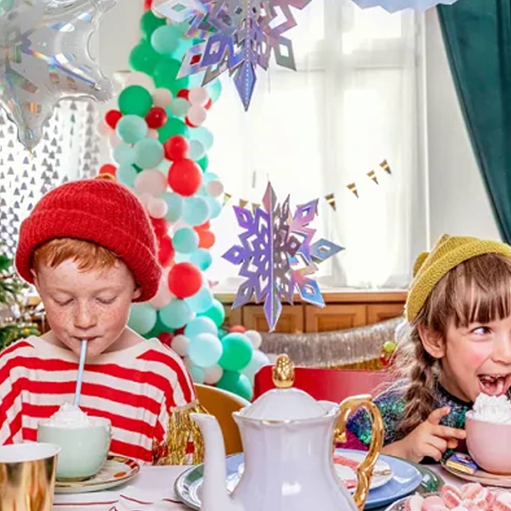 Twee kinderen drinken aan tafel met kerstversiering