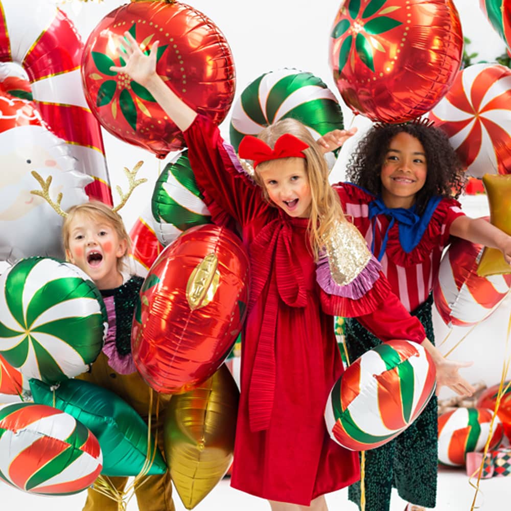Drie kinderen omringd door snoepvormige ballonnen
