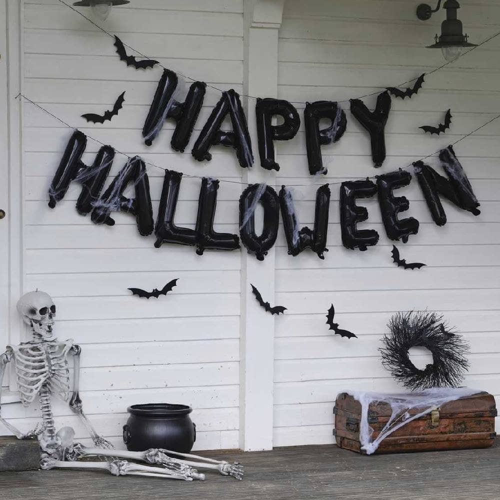 Halloween ballonnenslinger aan een muur met een skelet ervoor