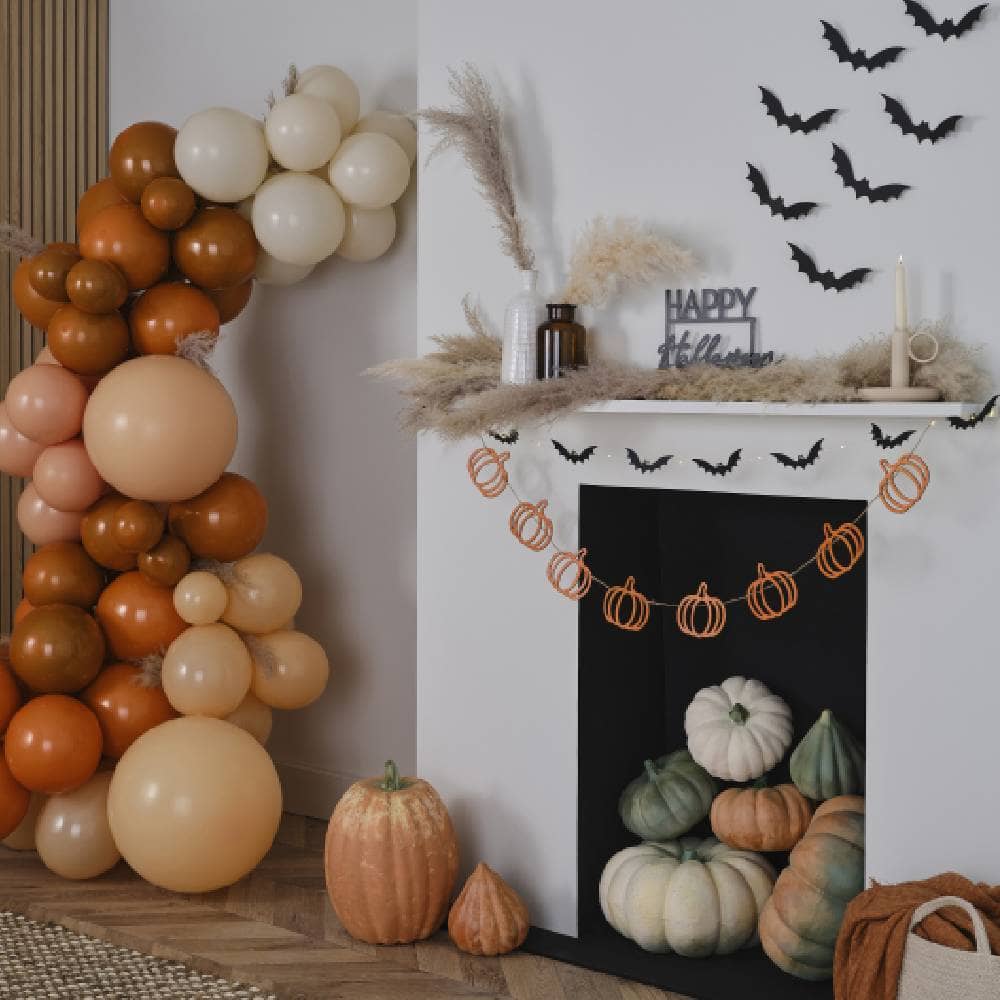 Versierde huiskamer voor halloween met oranje ballonnenboog