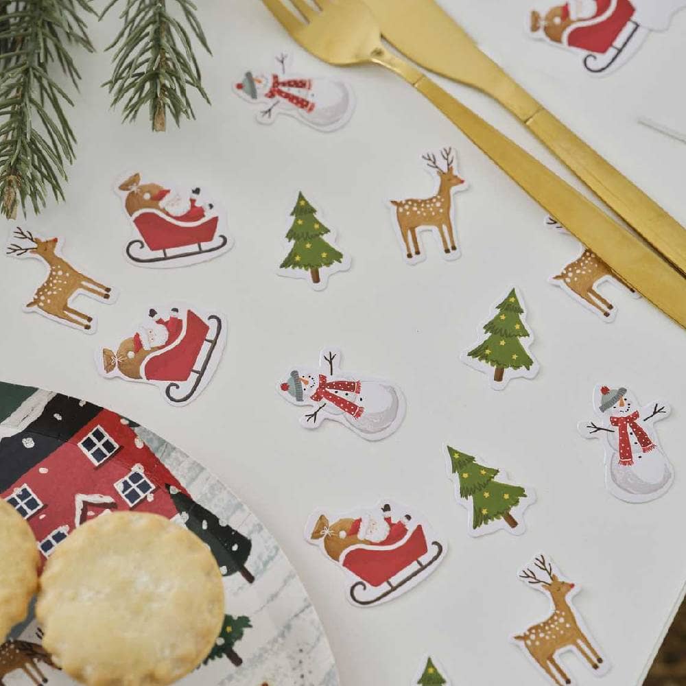 Confetti met kerstfiguren zoals sneeuwpoppen rendieren en kerstbomen op tafel