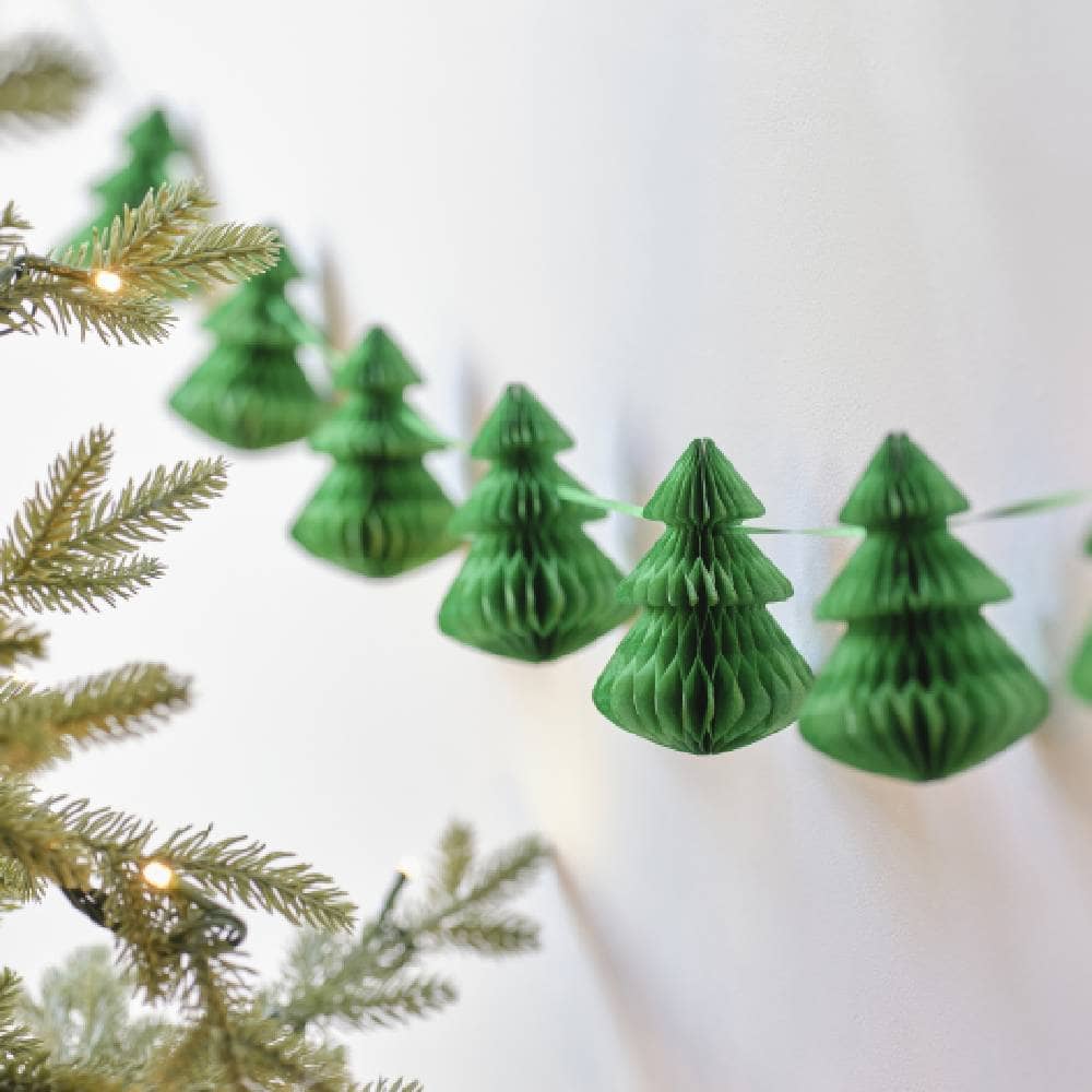 Slinger met groene honeycombs in de vorm van een kerstboom naast een echte kerstboom