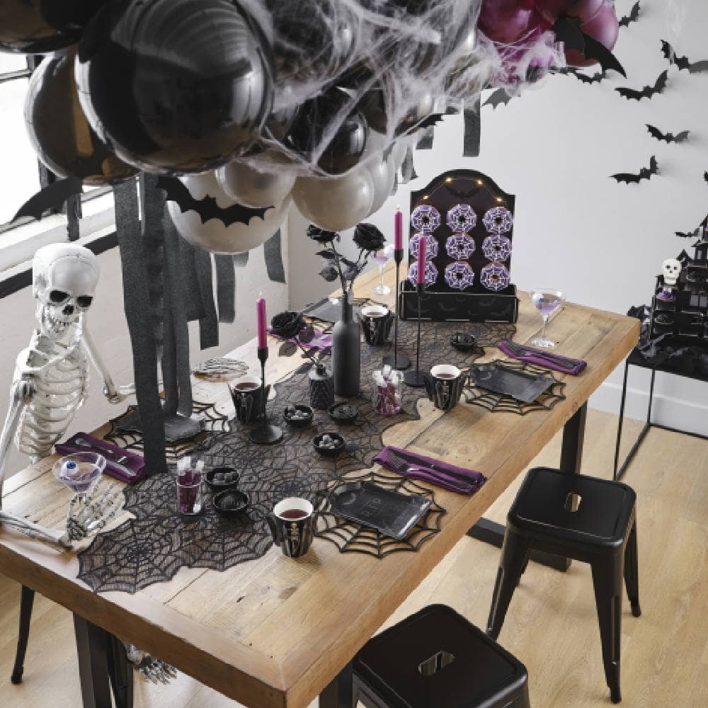 Gedekte halloween tafel met halloween versiering en skelet