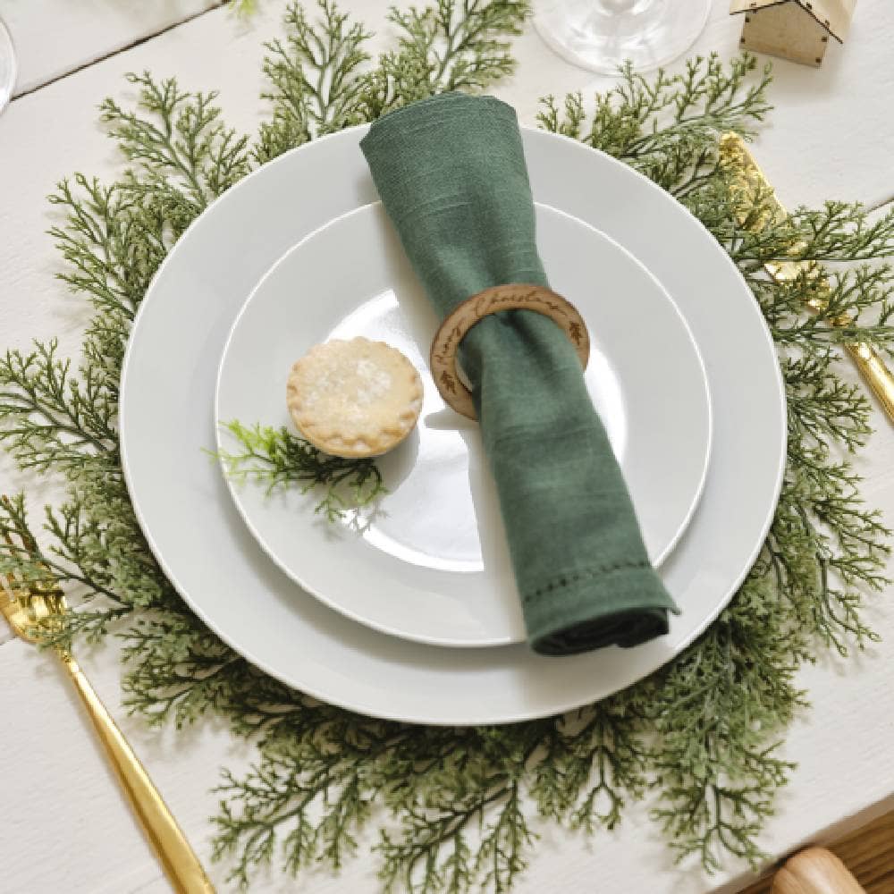 Hulst placemat met daarop twee witte borden met een groen servet met een houten servettenring eromheen