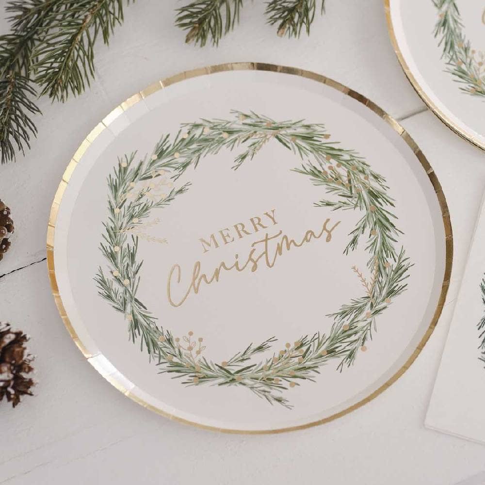 Wit bordje met gouden rand bedrukt met een kerstkrans en merry christmas op tafel