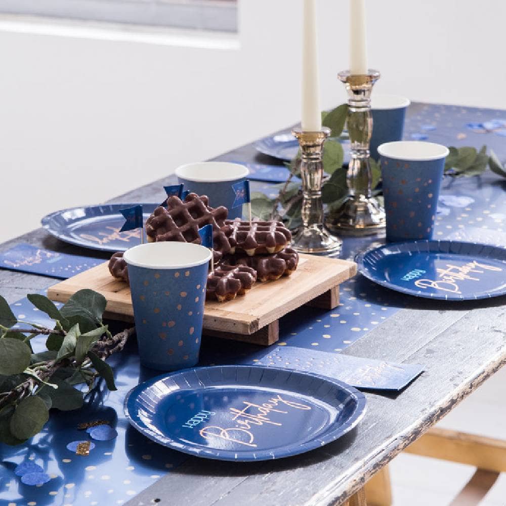Gedekte tafel met blauwe tafelloper bekers bordjes en chocolade wafels