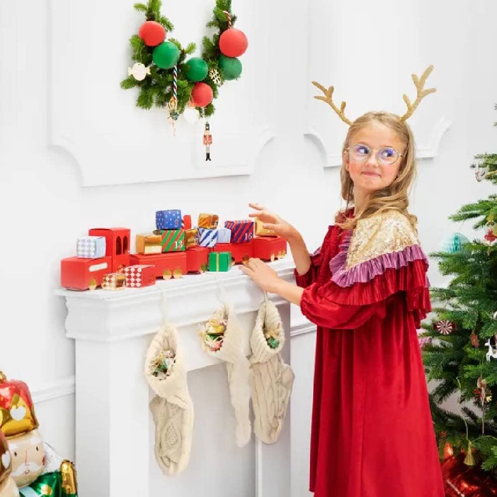 Meisje bij Kerstboom met rode advent kalender