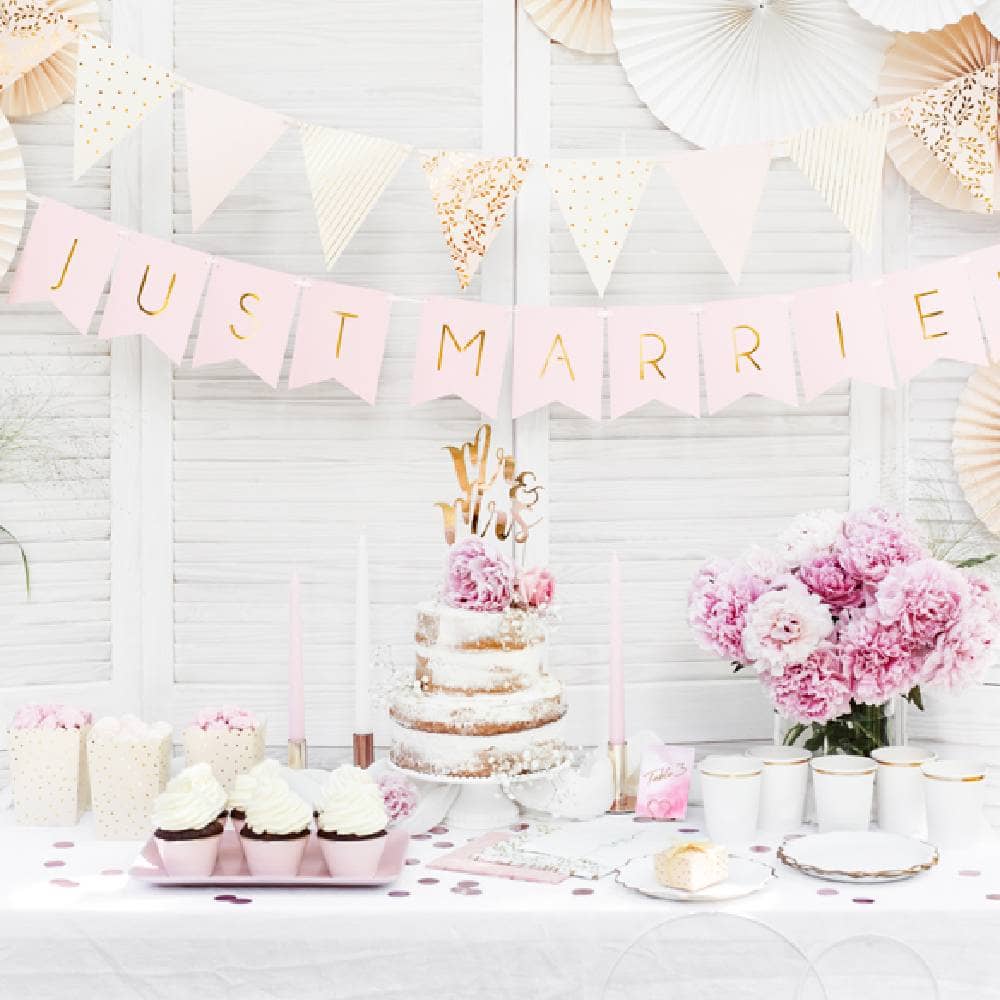 Versierde tafel met taart en cupcakes en slingers met Just Married
