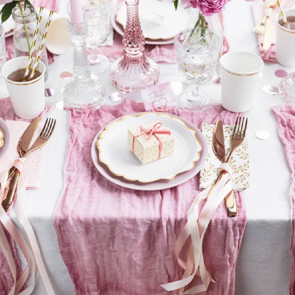 Versierde tafel met roze tafelloper, rosé gouden bestek en tafelkaartje