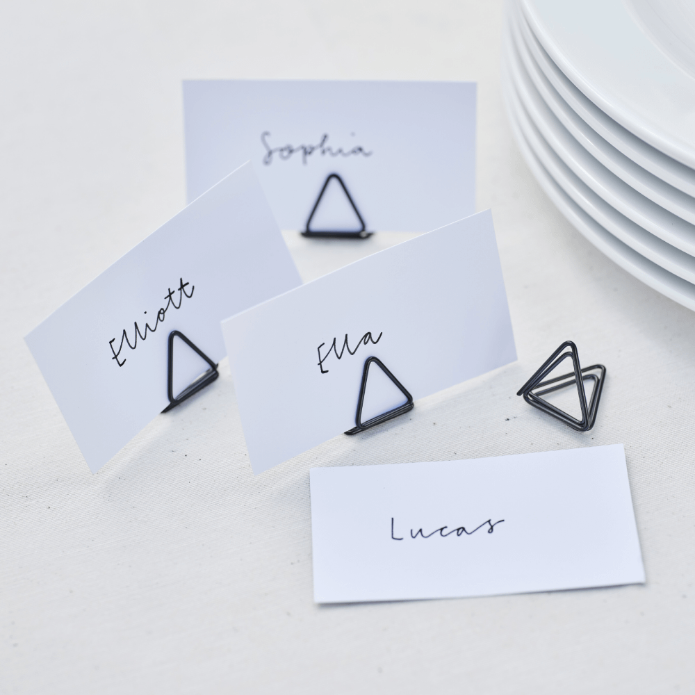 Kaarthouders in de vorm van een driehoek in het zwart met witte naamkaartjes met de namen Elliott, Sophia, Ella en Lucas