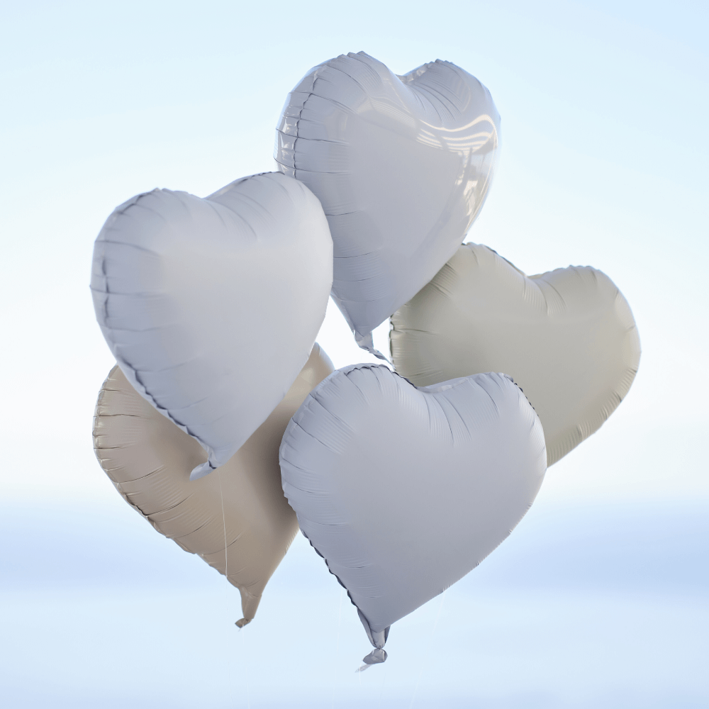 Folieballonnen in de vorm van hartjes in het creme, wit, taupe en grijs zweven voor een lichtblauwe en witte achtergrond