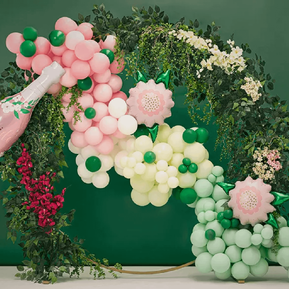 Ballonnenboog in pasteltinten in de kleuren groen, beige en roze voor een ring van bloemen en groene bladeren