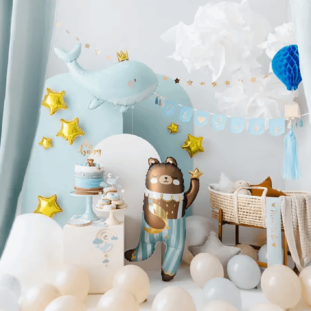 Blauwe babykamer versierd met folieballonnen in de vorm van een beertje en een walvis