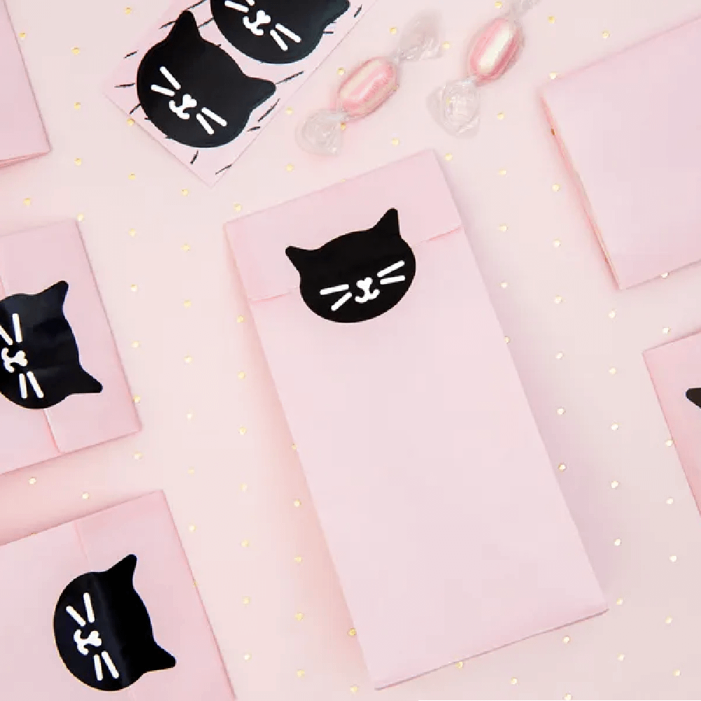 Roze zakjes dichtgeplakt met een zwarte sticker in de vorm van een kat