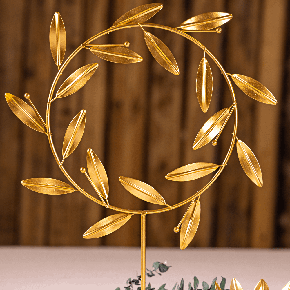 Gouden staander voor op tafel met gouden veren staat op een witte tafel voor een houten muur