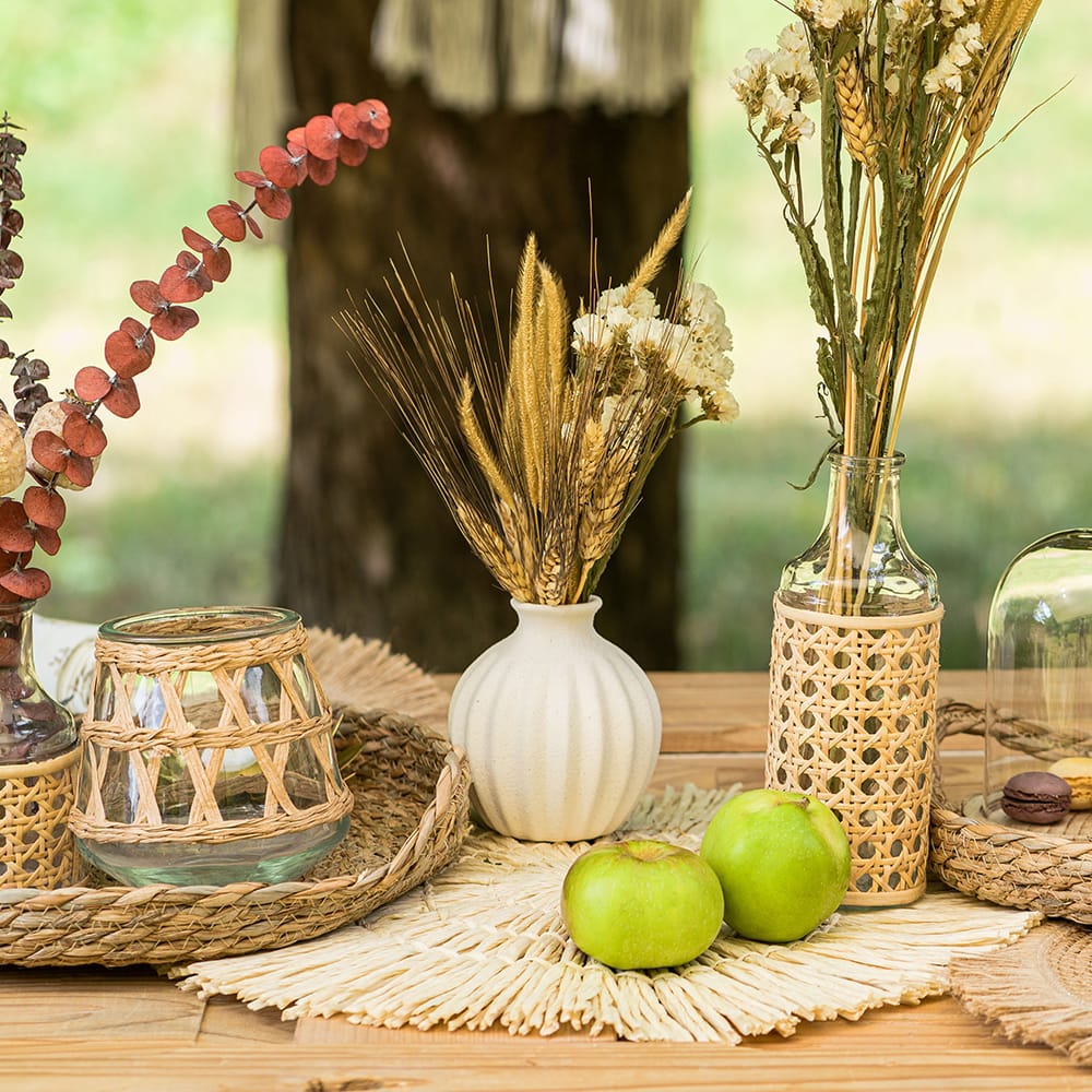 gedekte tafel met rieten placemat en dienbladen en vazen