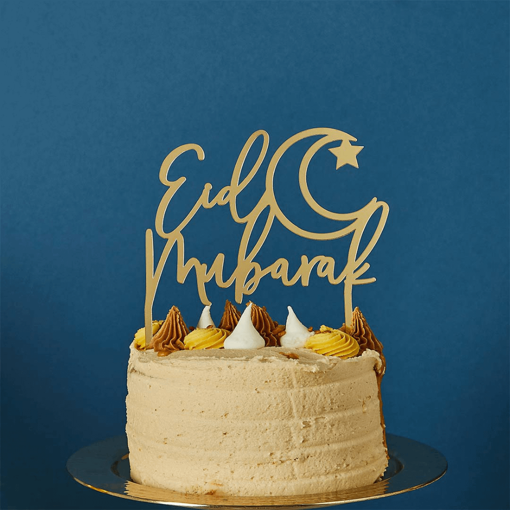 Gouden taart topper met de tekst eid mubarak zit in een taart voor een donkerblauwe achtergrond