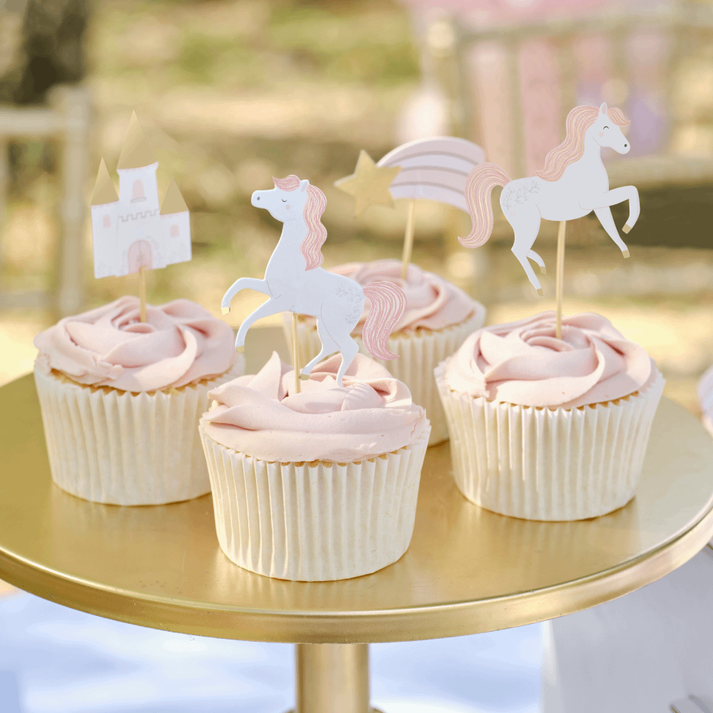 Cupcakes met roze decoratie staan op een gouden plateau en zijn versierd met cupcake toppes met prinsessenthema